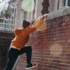 Ein Parkour-Athlet erklimmt eine hohe Mauer vor einem Gebäude