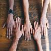 Hände verschiedener Hautfarben nebeneinander