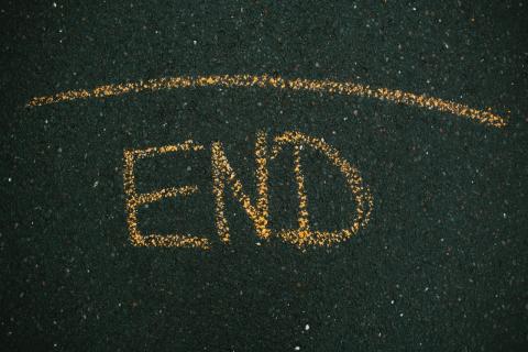Das Wort “End” mit gelber Kreide auf Asphalt geschrieben